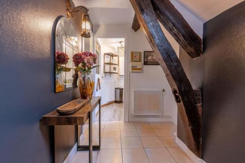 un couloir avec un vase de fleurs sur une table dans l'établissement Le Gentleman, à Orléans