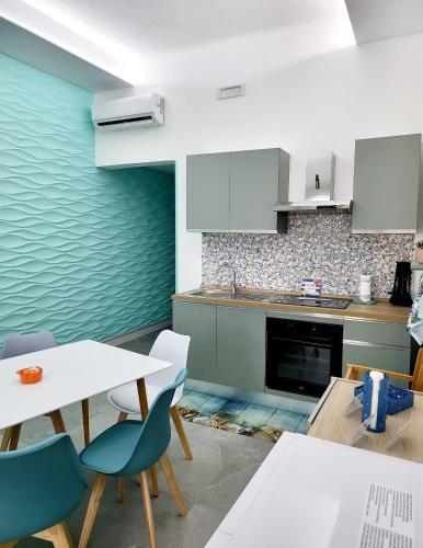 a kitchen with a table and some chairs and a counter at Aquamarina Rooms in Porto Cesareo