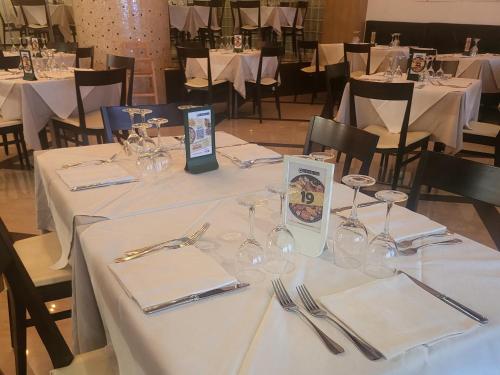 a table with white table cloths and wine glasses on it at Aquamarina Rooms in Porto Cesareo