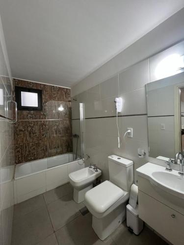 a bathroom with a toilet and a sink and a tub at Terra Malbec in Godoy Cruz