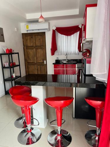 a kitchen with red stools at a kitchen counter at Quinta las praderas in Coyolar