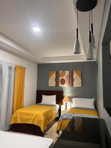 two beds in a small room with yellow sheets at Quinta las praderas in Coyolar