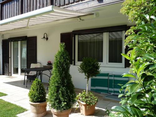 a patio with potted trees and a table in front of a house at Ferienwohnung Lehmann in Bad Endorf