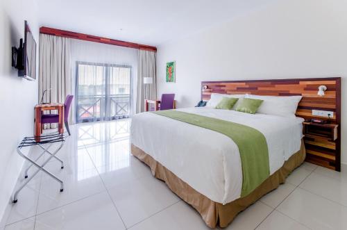 a bedroom with a large bed and a balcony at Hotel Babylon in Paramaribo