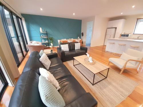 a living room with a leather couch and a table at Perfect on Orton in Ocean Grove