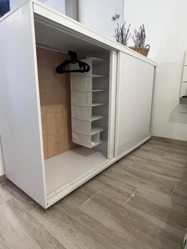 a white cabinet with shelves in a room at Apartamentos ESPIGAS PUERTO in Valencia