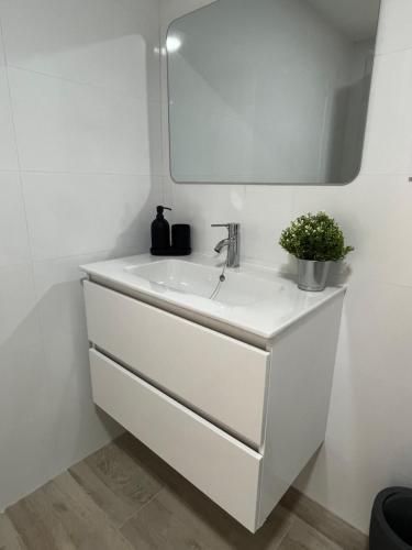 Un baño blanco con lavabo y espejo. en Apartamentos ESPIGAS PUERTO, en Valencia