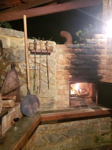a stone fireplace with a pot and a pan at Sítio em Lumiar com piscina natural, sauna, churrasqueira e lareira in Nova Friburgo