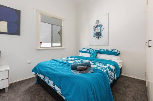 a bedroom with a blue bed and a window at Kitesurfer in Scarborough
