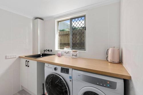 a kitchen with a washing machine and a sink at Kitesurfer in Scarborough