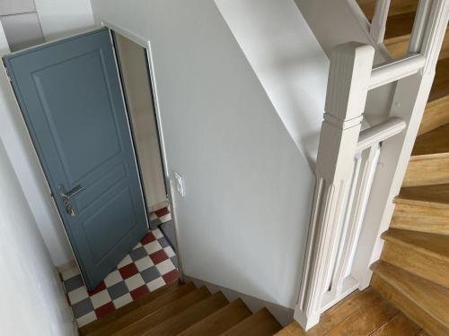 a blue door in a stairwell with a checkered floor at Topaze - Vue Mer & Fort - Confort & Evasion in Ambleteuse