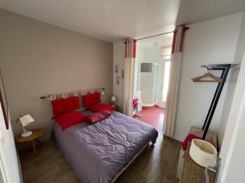 a bedroom with a bed with red pillows at Nacre - Vue Mer & Fort - Confort & Evasion in Ambleteuse