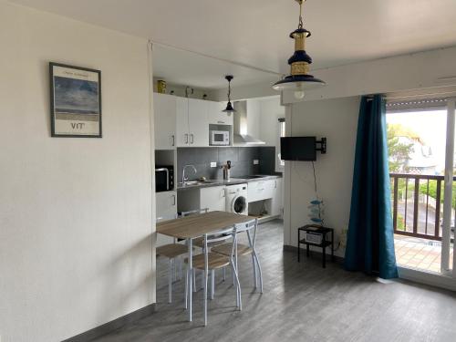 une cuisine et une salle à manger avec une table et des chaises dans l'établissement Appartement proche plage avec balcon, 4 couchages, parking privé, idéal pour familles! - FR-1-712-26, à Villers-sur-Mer