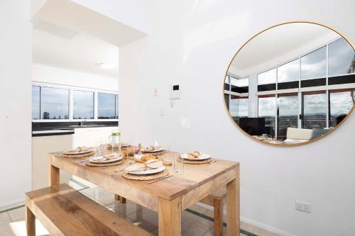 a dining room with a table and a mirror at Sunrise Penthouse in Tuncurry