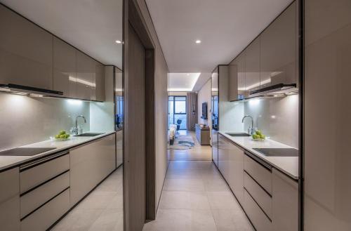 a kitchen with two sinks and a hallway at Fraser Residence Hanoi in Hanoi