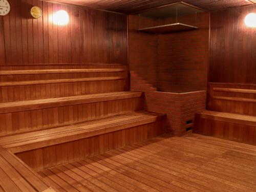 an empty sauna with wooden seats and a brick at Premier Hotel -Tsubaki- Sapporo in Sapporo