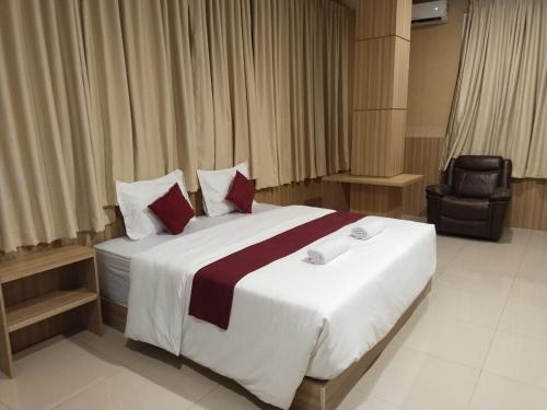 帕卢Hotel Kembang Joyo的卧室里有一张白色的大床，上面有红色的枕头