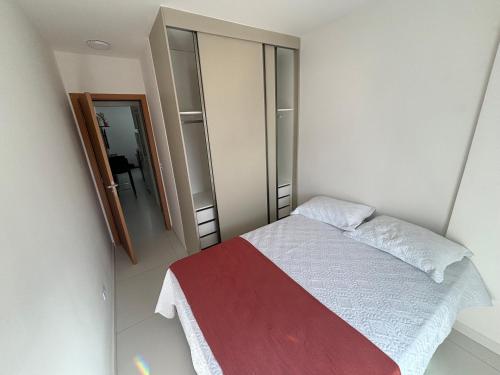 a small bedroom with a bed and a mirror at Novo Apto Canto do Forte, Rua Praia Vista Montanha, com Wi Fi, HomeBeach10, 01 Vaga de Garagem, Melhores Restaurantes ao lado in Praia Grande