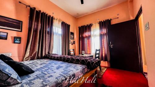 a bedroom with orange walls and a bed and windows at Hill Halt in Hawālbāgh