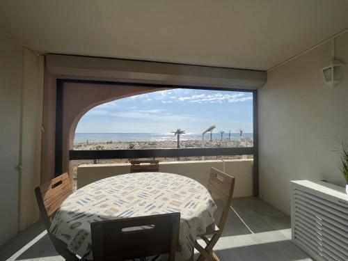 Cette chambre dispose d'une table et offre une vue sur la plage. dans l'établissement Le Barcarès: T2 moderne climatisé, au bord de mer, 4 pers, parking sécurisé - FR-1-799-4, au Barcarès