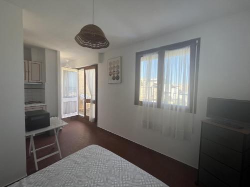 une chambre avec un lit, une table et des fenêtres dans l'établissement Le Barcarès, studio pour 2, terrasse, parking, animaux bienvenus, accès direct plage - FR-1-799-1, au Barcarès