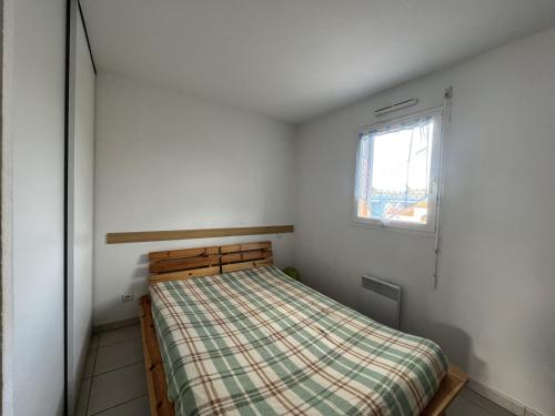 une petite chambre avec un lit et une fenêtre dans l'établissement Agréable T3 à 2 pas de la plage - 4P - Parking sécurisé - Animaux acceptés - FR-1-799-6, au Barcarès