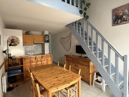 une salle à manger avec une table et un escalier dans l'établissement Agréable T3 à 2 pas de la plage - 4P - Parking sécurisé - Animaux acceptés - FR-1-799-6, au Barcarès