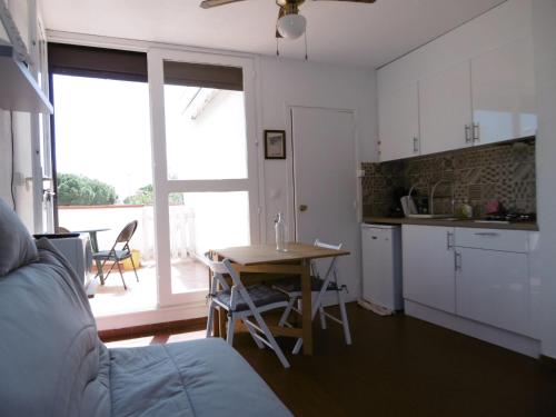 une cuisine et une salle à manger avec une table et une cuisine ainsi qu'une chambre dans l'établissement Studio Alcôve 3/4P, Grande Terrasse, Proche Plage - Parking Privé, Quartier Animé - Le Barcarès - FR-1-799-13, au Barcarès