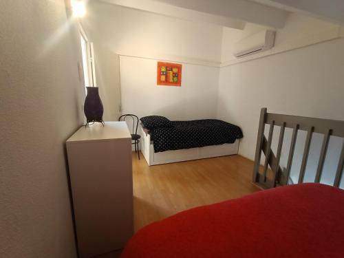 Cette petite chambre comprend un lit et une commode. dans l'établissement T2 Mezzanine Climatisé avec Terrasse - 5 Pers. Près Plage et Parc des Dosses - Parking Inclus - FR-1-799-17, au Barcarès