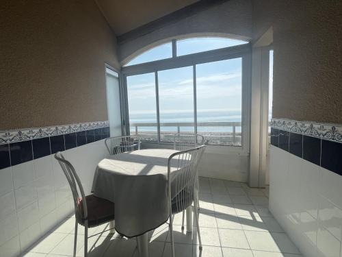 une salle à manger avec une table et des chaises et une fenêtre dans l'établissement Appartement T2 Cabine Mezzanine avec Parking à 50m de la Plage - FR-1-799-23, au Barcarès