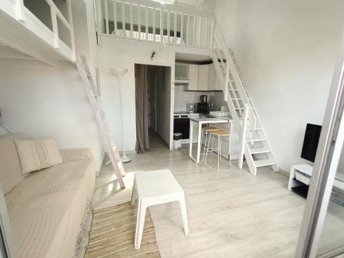 un salon blanc avec un canapé et une table dans l'établissement Studio mezzanine pour 4 avec loggia et vue mer, animaux admis - FR-1-799-25, au Barcarès