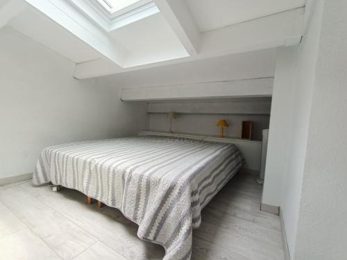 une chambre avec un lit dans une pièce blanche dans l'établissement Studio mezzanine pour 4 avec loggia et vue mer, animaux admis - FR-1-799-25, au Barcarès