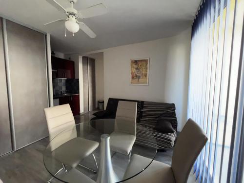 une salle à manger avec une table en verre et des chaises blanches dans l'établissement T2 au Barcarès - Accès direct plage, proche port, parking sécurisé - FR-1-799-19, au Barcarès