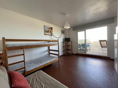 Cette chambre comprend 2 lits superposés et un balcon. dans l'établissement Agréable Studio en Bord de Mer avec Terrasse et Parking - Le Barcarès - FR-1-799-28, au Barcarès