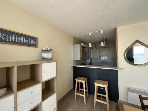 - une cuisine avec un comptoir et deux tabourets dans une pièce dans l'établissement Duplex T3 face mer avec terrasse, ascenseur, 5P, Grande Plage, parking sécurisé, animaux OK - FR-1-799-21, au Barcarès
