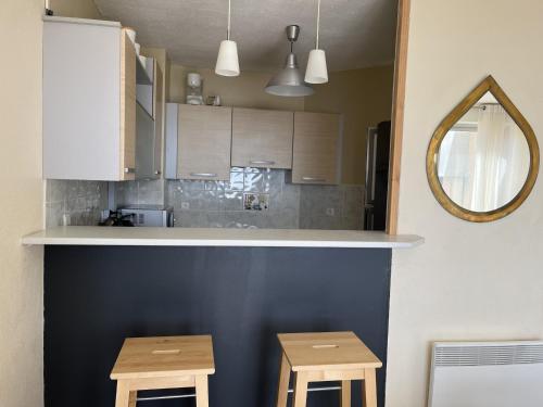una cucina con bancone e 2 sgabelli in legno di Duplex T3 face mer avec terrasse, ascenseur, 5P, Grande Plage, parking sécurisé, animaux OK - FR-1-799-21 a Le Barcarès