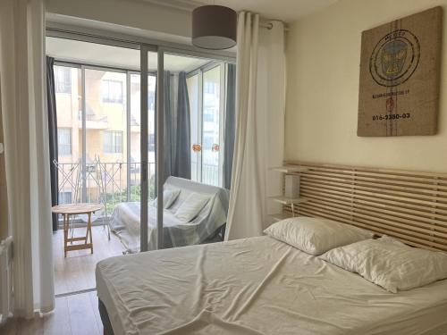 una camera da letto con un letto e un balcone di Duplex T3 face mer avec terrasse, ascenseur, 5P, Grande Plage, parking sécurisé, animaux OK - FR-1-799-21 a Le Barcarès