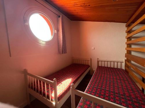 une petite pièce avec un lit et une fenêtre dans l'établissement Studio Mezzanine 4P avec Vue, Parking Privé - Le Barcarès - FR-1-799-16, au Barcarès