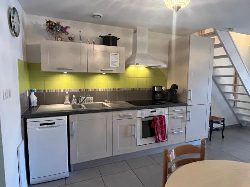 une cuisine avec des armoires blanches et un évier dans l'établissement Le Barcarès - Villa T3 Coquette - Résidence Calme - Proche Plage, Port, et Village - Parking Privé - FR-1-799-38, au Barcarès