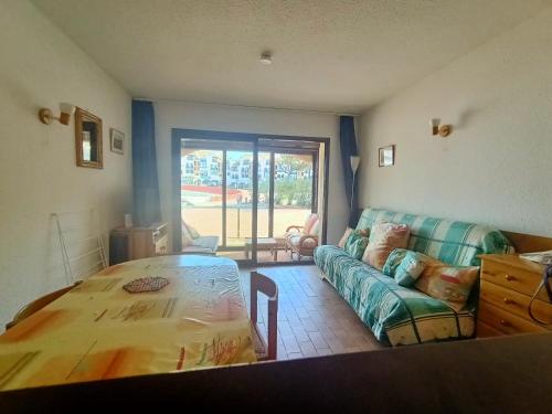 un salon avec une table et un canapé dans l'établissement Studio à Le Barcarès avec Piscine – 4 Pers, Animaux OK, Parking - FR-1-799-40, au Barcarès
