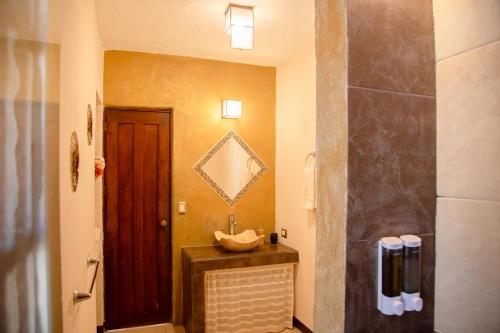 a bathroom with a sink next to a door at Condominio con Alberca en la Zona Hotelera Puerto Vallarta in Puerto Vallarta