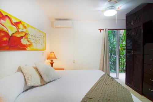 a bedroom with a bed and a painting on the wall at Condominio con Alberca en la Zona Hotelera Puerto Vallarta in Puerto Vallarta