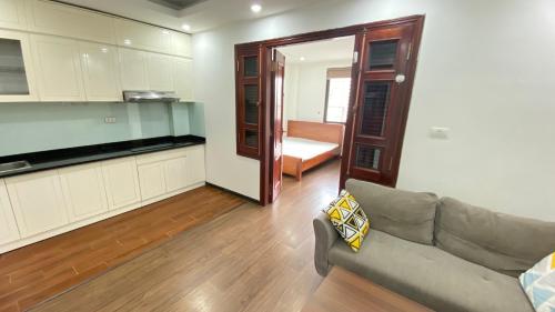 a living room with a couch and a kitchen at Era Apartment La Thành in Hanoi