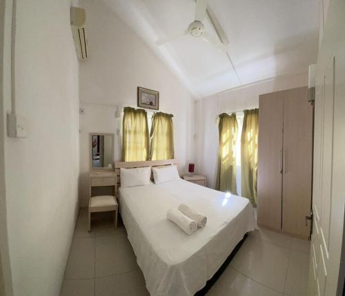 a bedroom with a white bed with two towels on it at Paloma Villa - Villa Moderne et Privée avec 4 chambres-à-coucher - 5 min de la Plage Flic en Flac in Flic-en-Flac