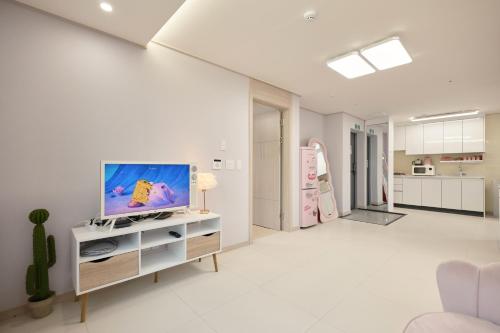 ein Wohnzimmer mit einem Flachbildfernseher auf einem Schrank in der Unterkunft Pink room 4 bedroom in Seoul
