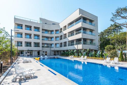 a hotel with a swimming pool in front of a building at Dongho Beach Hotel in Gochang 