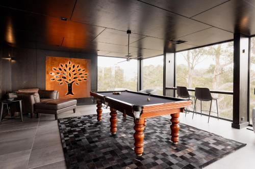 a pool table in a room with a tree on the wall at Luxe Hobart Villa - Boxwood in Hobart