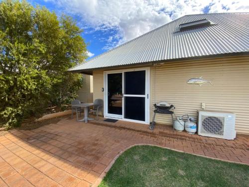 a house with a patio with a table and a grill at Osprey Holiday Village Unit 203 1 Bedroom in Exmouth
