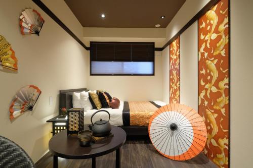 a bedroom with a bed and a table with a fan at 国際通りまで車で5分 那覇空港まで車で8分 最大15名 As bld in Makishimachi