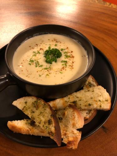 a bowl of soup and some bread on a plate at Cafe Moto Hostel in Puerto Princesa City